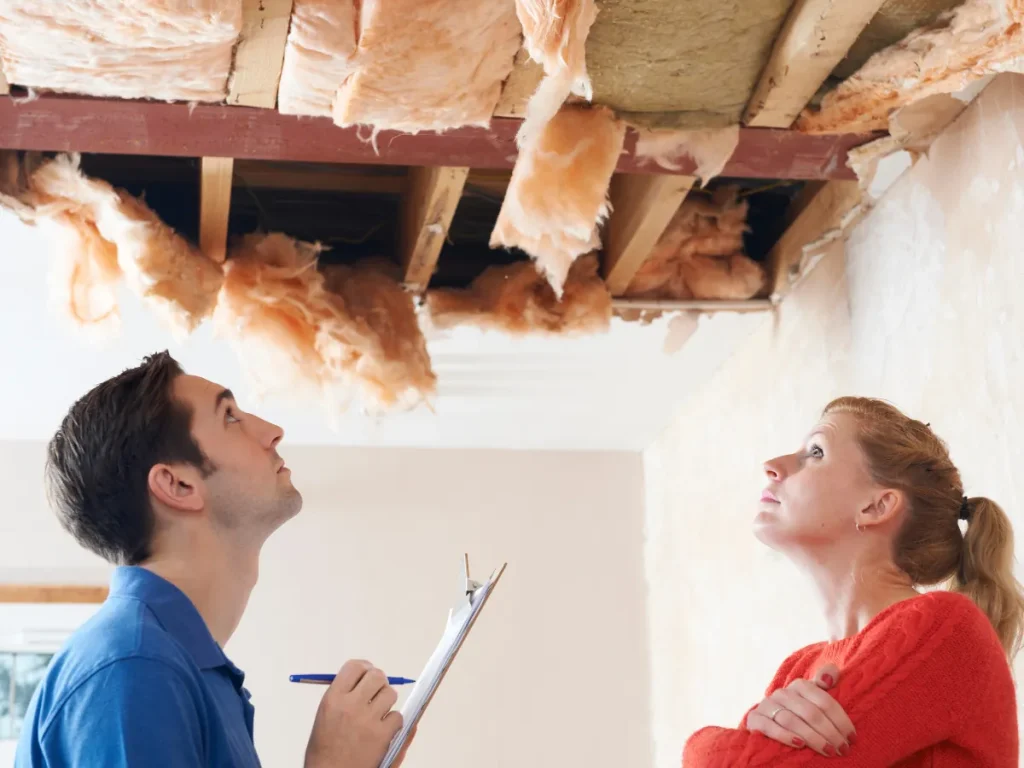 a man and woman looking at a ceiling for roof inspection in shavertown