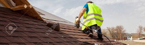 Roofing contractor works on residential roof
